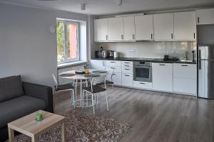 a kitchen with a couch and a table in a room at Rundale Solstice Apartment in Pilsrundāle