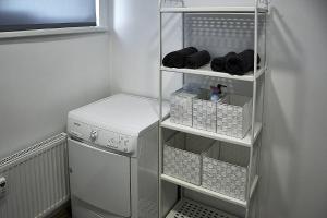 lavadero blanco con lavadora y secadora en Rundale Solstice Apartment, en Pilsrundāle