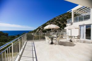 a balcony with tables and chairs and the ocean at Villa Blanca in Petrovac na Moru