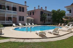 a swimming pool with lounge chairs and a building at PEACEFUL HOUSE in Fethiye