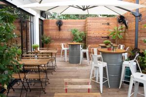 an outdoor patio with tables and chairs and an umbrella at Hotel 75 by Prima Hotels in Tel Aviv