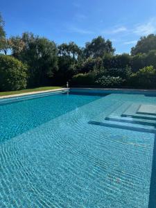 uma grande piscina com azulejos azuis em La Tour de la Rose - Villa Bohemian em Valbonne