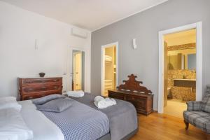 a bedroom with a large bed and a chair at Luxury Pontevecchio 5 Stars Apartment in Florence