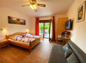 um quarto com uma cama e um sofá em Guesthouse Mesec Zaplana em Vrhnika