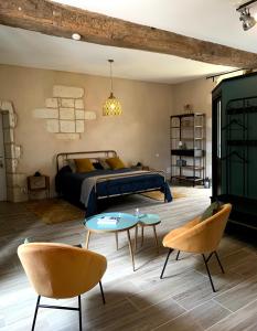 a bedroom with a bed and tables and chairs at La Gouronerie in Parçay-sur-Vienne