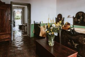 a vase of flowers on a table in a bedroom at Hotel I Cinque Balconi in Santa Marina Salina