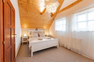 sypialnia z łóżkiem i drewnianym sufitem w obiekcie Chata nad lázeňským údolím w mieście Luhačovice