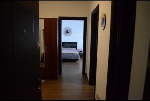 een hal met een slaapkamer met een bed en een klok bij Vivamus Studio in Braşov