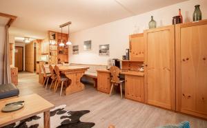 a large kitchen with wooden cabinets and a table at Rothornblick 41 by Arosa Holiday in Arosa