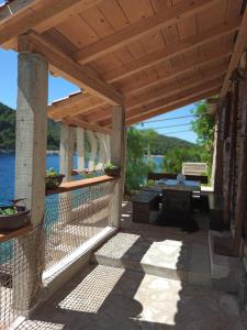 pérgola de madera con mesa en el patio en Sea side house for two in a wilderness en Vis