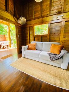 a white couch in a room with wooden walls at Banana Cottage Ecolodge & Spa in Le Gosier