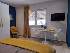 a room with a table and chairs and a window at Apartments Suha Punta - Villa Babalonija in Kampor