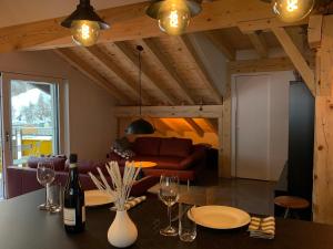 una sala de estar con una mesa con copas de vino en "alti Post" zentralgelegene, stilvolle Dachwohnung, en Täsch