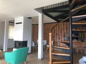 ein Wohnzimmer mit einer Treppe und einem grünen Stuhl in der Unterkunft Bakuriani Fun, nice view and design, cosy and spacious in Bakuriani