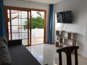 ein Wohnzimmer mit Sofa und Fernseher in der Unterkunft Garden City in Playa Fañabe