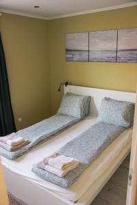 2 Betten in einem Zimmer mit Handtüchern darauf in der Unterkunft Pine&Chill2 Apartments in Balatonalmádi