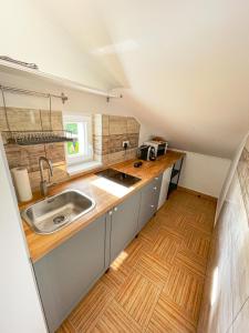 uma pequena cozinha com lavatório e piso em madeira em Pine&Chill2 Apartments em Balatonalmádi