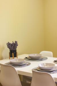 uma mesa com cadeiras, pratos e flores em Pine&Chill2 Apartments em Balatonalmádi
