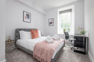 a bedroom with a bed and a desk and a window at Skye Sands - Swilken Garden Residence - St Andrews in St. Andrews