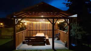 a wooden gazebo with a bench and lights at Domek Olivia Wilkasy, Mazury in Wilkasy