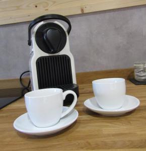 a coffee maker and two cups on a table at Harlosh Hideaways - Aurora Pod in Harlosh