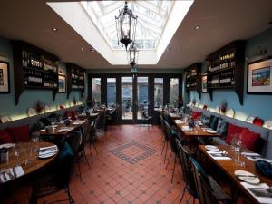 une salle à manger avec des tables et des chaises dans un restaurant dans l'établissement Gilbey's Bar, Restaurant & Townhouse, à Windsor