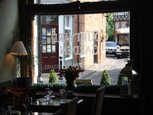 a table in a restaurant with a view of a street at Gilbey's Bar, Restaurant & Townhouse in Windsor