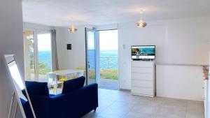 un salon avec une chaise bleue et une table dans l'établissement Villa Costa Bianca by ArgonautiVacanze, à Portoferraio