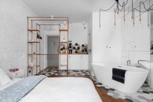 a white bathroom with a tub and a bed at Apartament Centrum- Nowy Świat in Warsaw