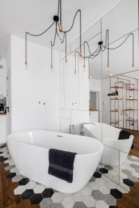 uma casa de banho com 2 banheiras brancas num piso xadrez em Apartament Centrum- Nowy Świat em Varsóvia