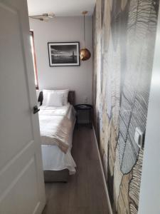 a small bedroom with a bed and a wall at Apartament Latarnik- STANDARD in Gąski