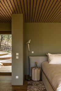 a bedroom with a bed and a wooden ceiling at Souki ~ Lodges & Spa in Cabrières +77 photos