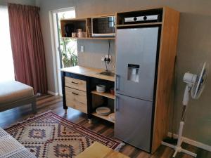a kitchen with a refrigerator and a desk with a microwave at Tranquility in Parow