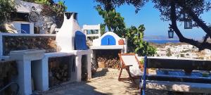 a bench and a building with a view of the ocean at Prickly Pear House in Plaka Milou