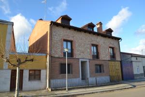 un viejo edificio de ladrillo al lado de una calle en La Cantamora Hotel Rural Pesquera de Duero, en Pesquera de Duero