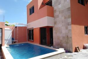 una casa con piscina al lado de un edificio en ALCOBY APARTMENT, en Cancún