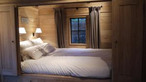 1 dormitorio con 1 cama grande y ventana en B&B Hemel & Haard, en Assenede