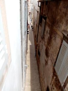 a narrow alley in an alleyway between two buildings at San Eleuterio Guesthouse in Poreč