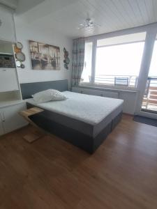1 dormitorio con cama y ventana grande en Haus Enzian - Apartment Gerlitzen en Kanzelhöhe