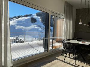 a room with a balcony with a view of a mountain at All.Glemm RIDERS SUITE in Saalbach-Hinterglemm