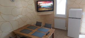 a room with a table and a television on a wall at Domek Olivia Wilkasy, Mazury in Wilkasy