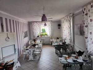 a dining room with tables and chairs and a window at Pokoje Gościnne U Broni in Mielno