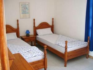 two twin beds in a room with two tables at Maravilla Bungalows in El Cotillo