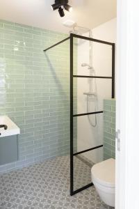 a bathroom with a glass shower with a toilet at Paradise Beach Studio in Zandvoort
