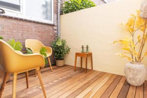 a patio with two chairs and a vase with plants at Paradise Beach Studio in Zandvoort