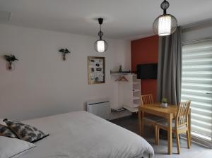 a bedroom with a bed and a table and a television at Studio Les chambres de la source - Tadorne in Sancourt