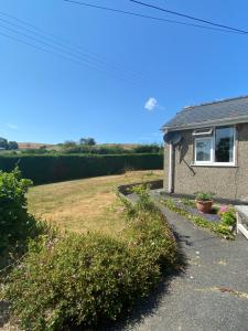 a house with a lawn and a yard with flowers at tabor lane Dolwar our little cottage in Criccieth