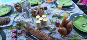 een tafel met een tafelkleed met eten en drinken bij LA MAISON DU PONT DU GARD in Vers Pont du Gard