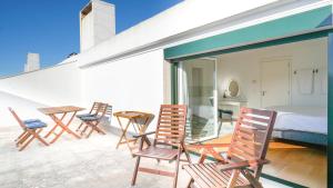 - un ensemble de chaises et un lit sur un balcon dans l'établissement Lisbon Best Places - Rooftop, à Lisbonne