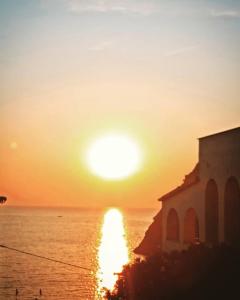 un tramonto sull'oceano con una chiesa di ISCHIA è Vita ! a Ischia